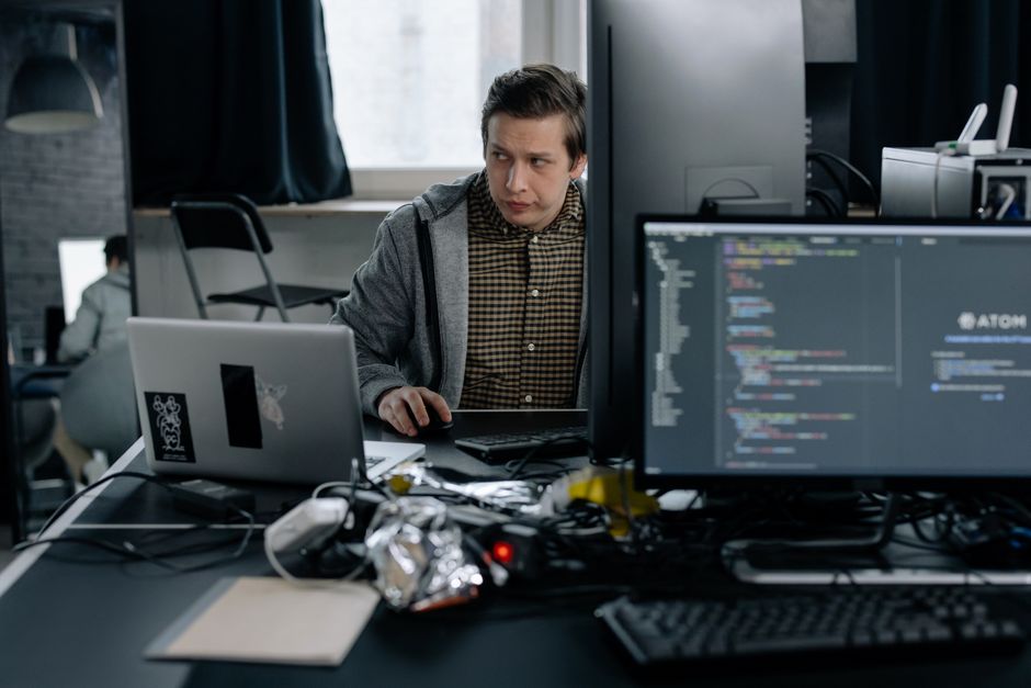A programmer in a modern office working on computer code.